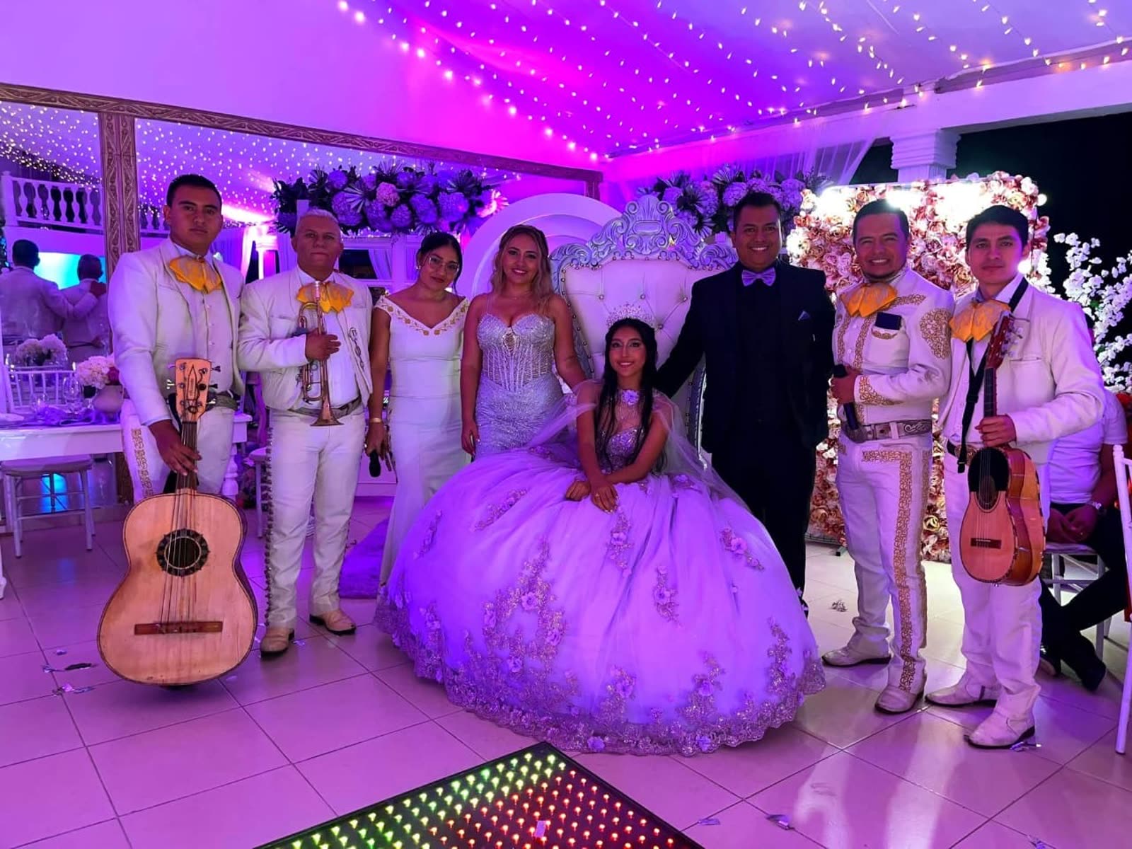 Quinceañera junto a Mariachi Los Potrillos en un salón iluminado en Mallorca